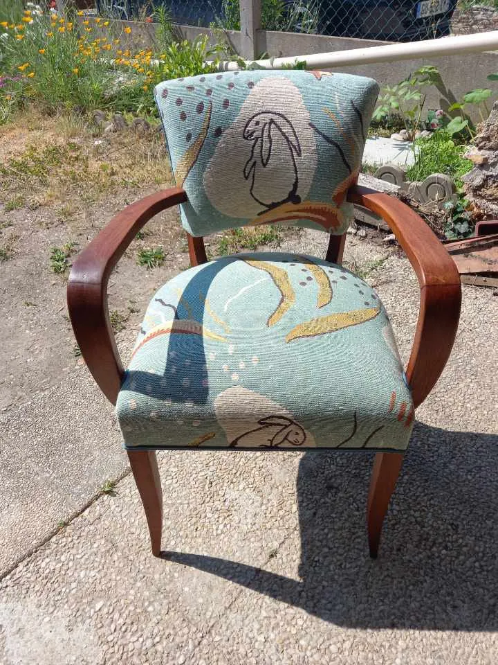Fauteuil bridge garni d'un tissu à motifs animaliers dans les tons verts, présenté au jardin