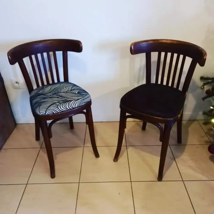 Fauteuil en bois aux accoudoirs sculptés, assise et manchettes en tissu rouge à chevrons, devant une cheminée