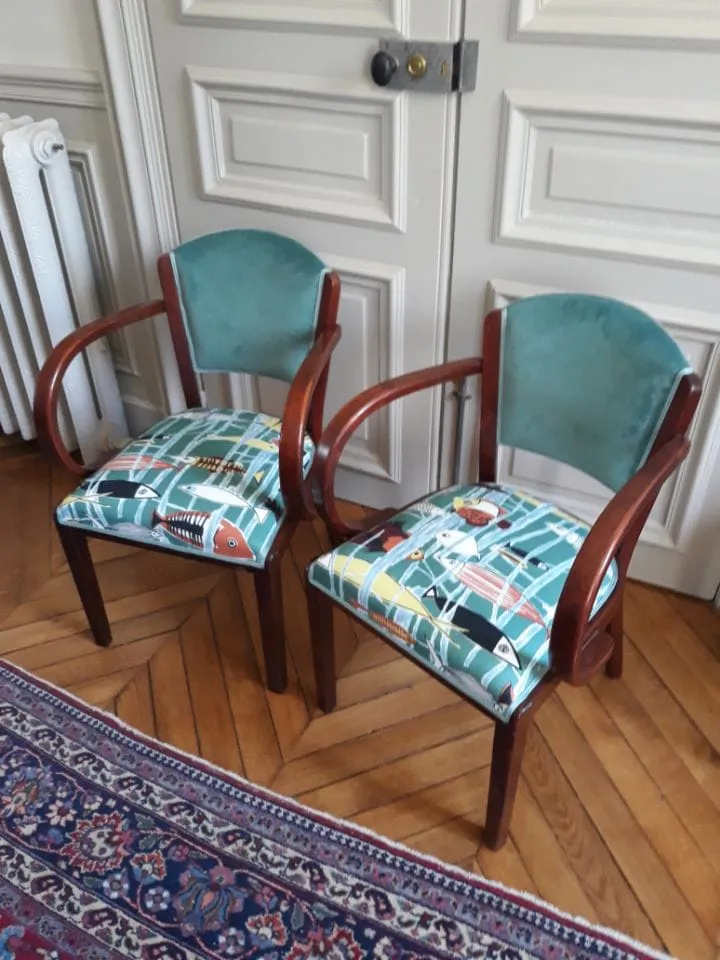Paire de fauteuils bridge garnis de velours vert canard et d'assises à motifs marins, devant une double porte