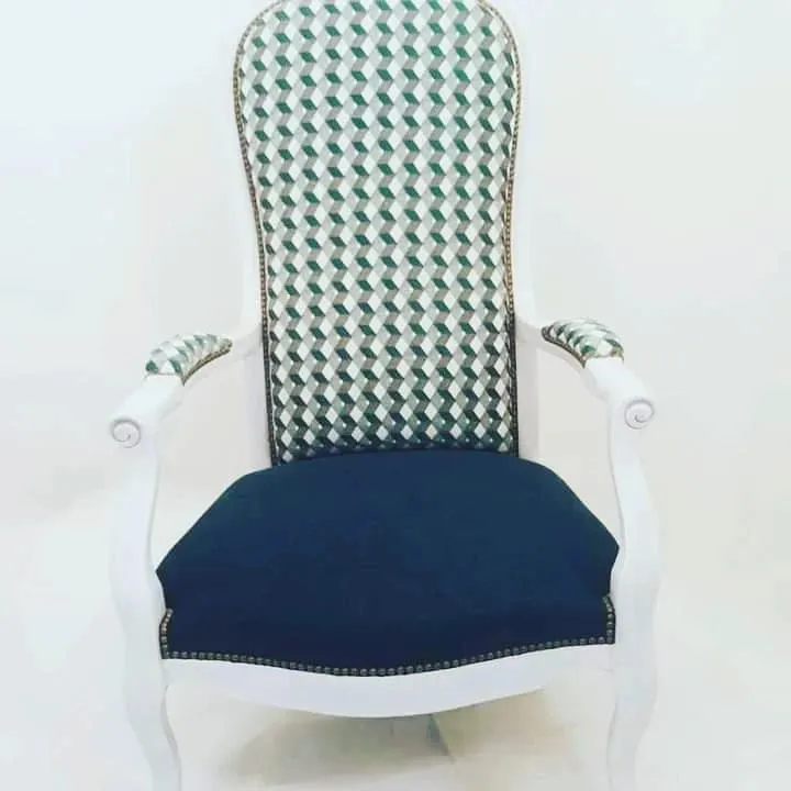 Fauteuil au dossier garni d'un tissu à chevrons vert et blanc et à l'assise bleu marine, sur fond clair